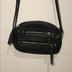 Cross body black purse with four zippers.